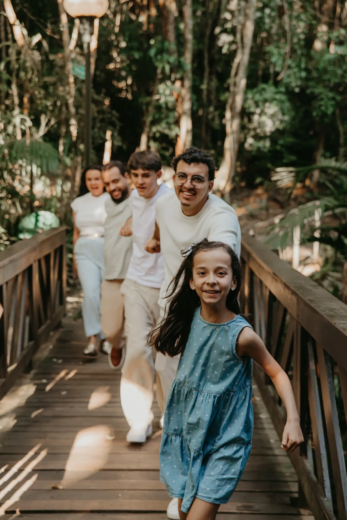 Família correndo em uma passarela de madeira