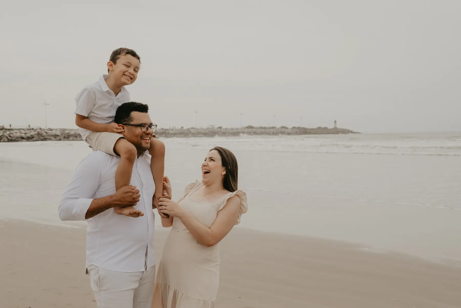 Família sorrindo durante ensaio na praia